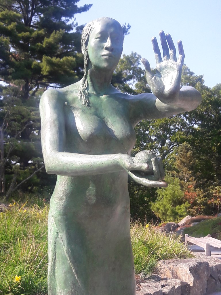 Statue of woman holding hands upward and outward.
